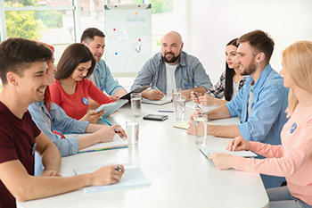 men and women around a business table